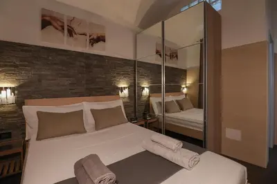 a bedroom with a large white bed with mirrors at [Roma Termini] - Suite elegante in Rome