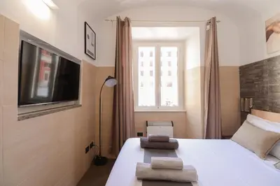 a bedroom with a bed and a tv and a window at [Roma Termini] - Suite elegante in Rome