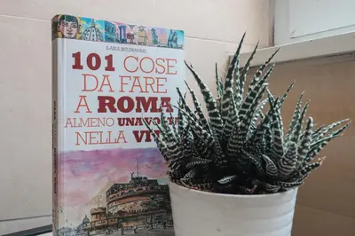 a book and a plant in a pot next to a book at [Roma Termini] - Suite elegante in Rome