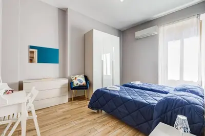 a bedroom with a blue bed and a desk at My Sweet R-home in Vatican in Rome