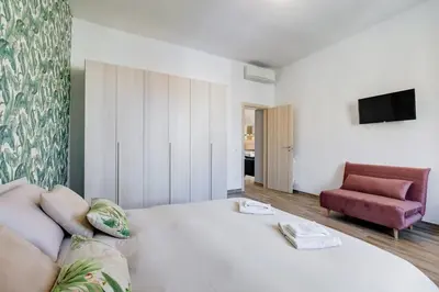 a bedroom with a large white bed and a couch at My Sweet R-home in Vatican in Rome