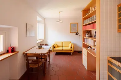 a living room with a table and a yellow chair at Quiet apartment in the heart of Trastevere in Rome