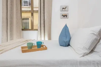 a bed with two cups and a wooden tray on it at Bell Appartamento in Rome