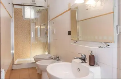 a bathroom with a sink and a toilet and a mirror at Bell Appartamento in Rome