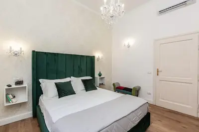 a bedroom with a large bed with a green headboard at Portico d'Ottavia LUX in Rome