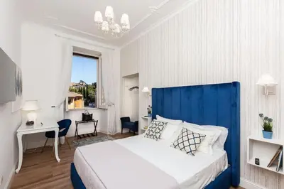a bedroom with a large bed with a blue headboard at Portico d'Ottavia LUX in Rome