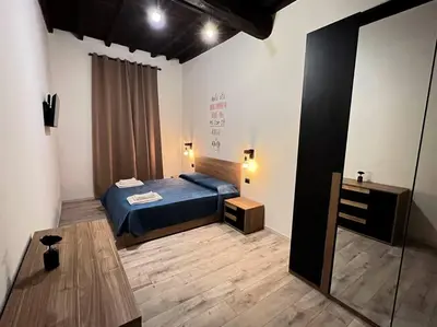 a bedroom with a blue bed and a wooden floor at Nannì Vatican House in Rome