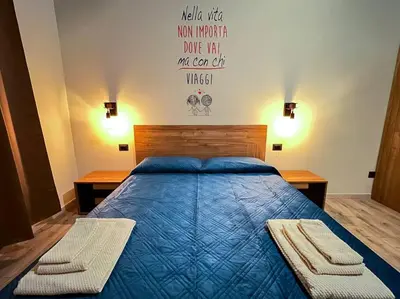 a bedroom with a blue bed with two benches at Nannì Vatican House in Rome