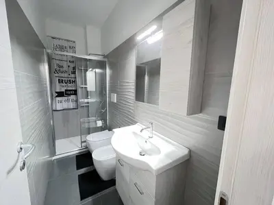 a white bathroom with a sink and a toilet at Nannì Vatican House in Rome