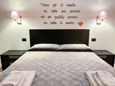 a bedroom with a bed with a quote on the wall at Nannì Vatican House in Rome