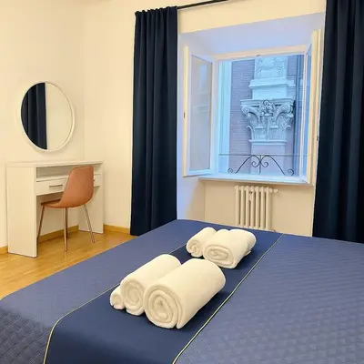 a bedroom with a blue bed with towels on it at Dimora Centro Storico Roma in Rome