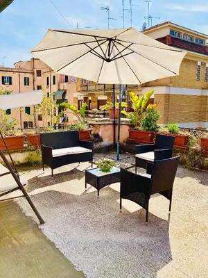 a patio with an umbrella and tables and chairs at La Casetta di San Giovanni 1924 in Rome