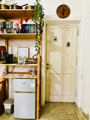 a kitchen with a door and a shelf with books at La Casetta di San Giovanni 1924 in Rome