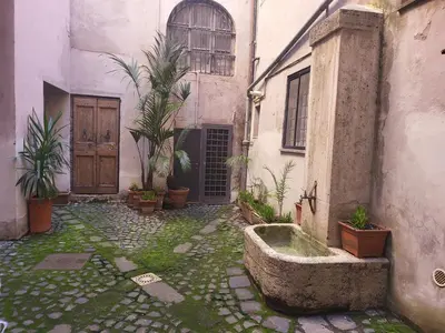 an old building with a courtyard with a water fountain at The Rabbit Hole in Rome
