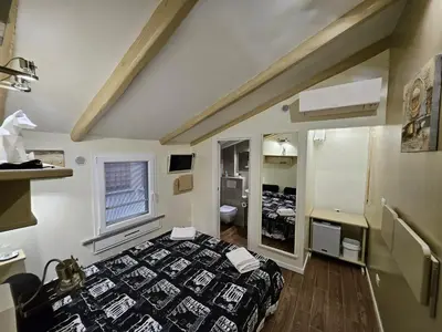 a small room with a bed and a mirror at The Fox Cove in Rome