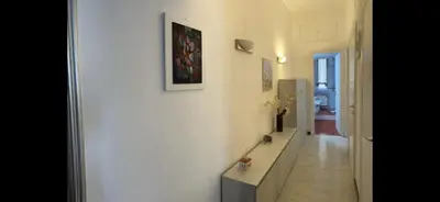 a hallway with a white wall with a picture on it at TRADITIONAL ROME Stay in Rome