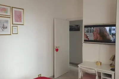 a room with a table and a tv on a wall at Delizioso appartamento San Pietro in Rome