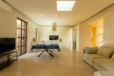 a living room with a table and a couch at Pelliccia 11 Trastevere Penthouse in Rome