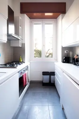 a white kitchen with a stove and a window at Appio11 Apartment in Rome