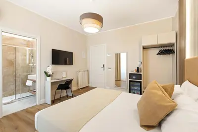 a bedroom with a large white bed and a desk at AlbaDea Deluxe in Rome