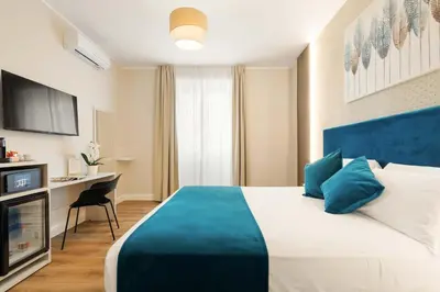 a hotel room with a large bed and a desk at AlbaDea Deluxe in Rome