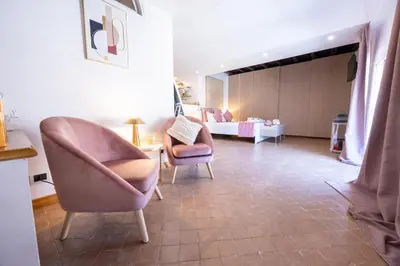a living room with two chairs and a bedroom at MB SUITES Margutta in Rome