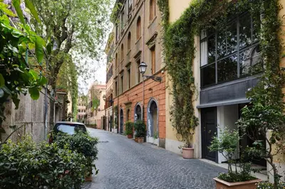 an alley with a car parked on a cobblestone street at MB SUITES Margutta in Rome