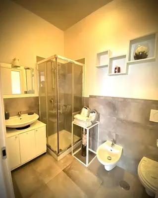 a bathroom with a shower and a toilet and a sink at I-LARI Apartment in Rome