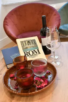 a table with a plate with a bottle of wine and glasses at Roma Clodio Holiday in Rome