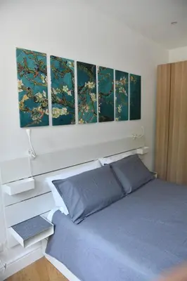 a bedroom with a bed with four paintings on the wall at Roma Clodio Holiday in Rome