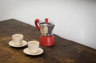 a red coffee maker and two cups on a table at Angelico By Rental in Rome in Rome