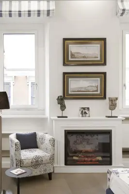 a living room with a chair and a fireplace at Carthusia Suites Roma in Rome