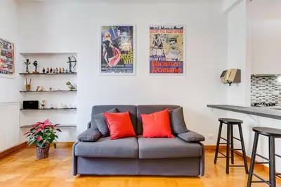 a living room with a couch with two red pillows at AM House Colosseo in Rome