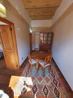 a dining room with a table and chairs on a rug at 1878s by SC LUXURY HISTORIC HOUSE PIAZZA DI SPAGNA in Rome