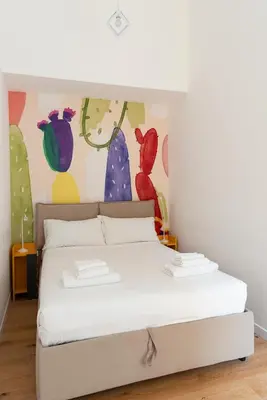 a white bed in a room with a painting on the wall at Designer Apartment Via Nazionale in Rome