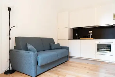 a living room with a blue couch in a kitchen at Designer Apartment Via Nazionale in Rome