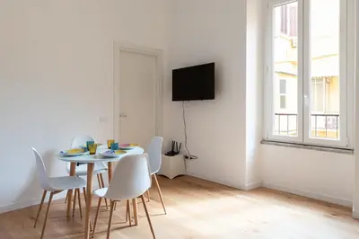 a dining room with a table and white chairs at Designer Apartment Via Nazionale in Rome