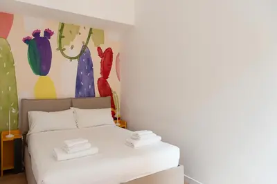 a bedroom with a white bed with a painting on the wall at Designer Apartment Via Nazionale in Rome