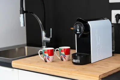 two coffee cups on a cutting board next to a coffee maker at Designer Apartment Via Nazionale in Rome