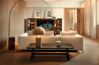a living room with a couch and a tv at Bvlgari Hotel Roma in Rome