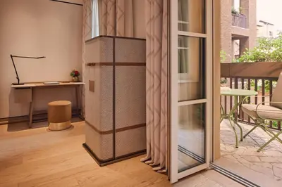 a hotel room with a bed and a chair at Bvlgari Hotel Roma in Rome