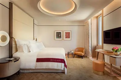 a hotel room with a large bed and a desk at Bvlgari Hotel Roma in Rome