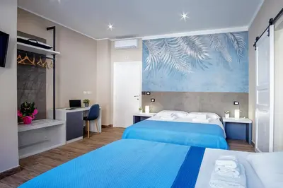 a hotel room with two beds with blue sheets at Venturi Comfort in Rome