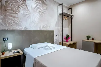 a bedroom with a white bed and a wall at Venturi Comfort in Rome