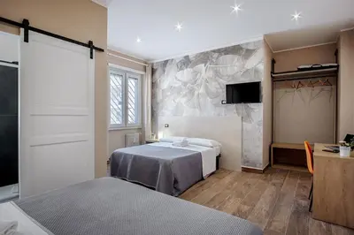 a bedroom with two beds and a tv on a wall at Venturi Comfort in Rome