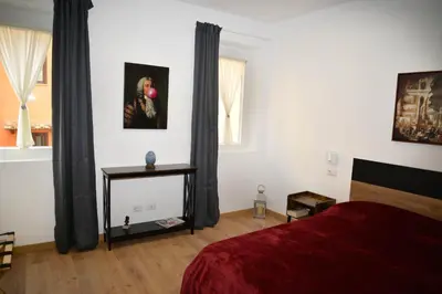a bedroom with a red bed and a window at Fidia Palace Claudia's apartment Colosseo in Rome