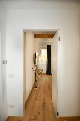 a hallway with white walls and a wooden floor at Fidia Palace Claudia's apartment Colosseo in Rome