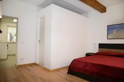 a bedroom with white walls and a red bed at Fidia Palace Claudia's apartment Colosseo in Rome