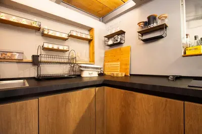 a kitchen with a black counter top and wooden cabinets at Trastevere Loft in Rome