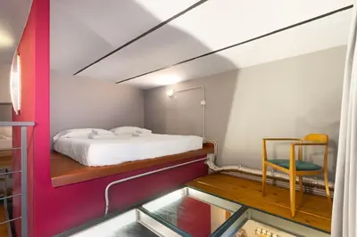 a small bedroom with a bed and a chair at Trastevere Loft in Rome
